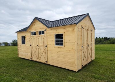 Tan Amish shed with black roof, multiple windows and two double doors