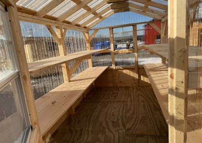 Interior of an Amish-built greenhouse with wood shelving