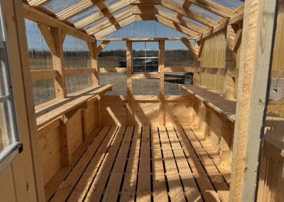 Interior of an Amish greenhouse showing wood frame shelving