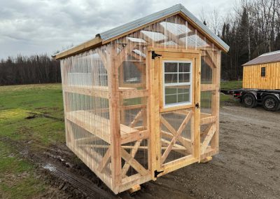Close-up of an Amish greenhouse with wood window frame and polycarbonate wall