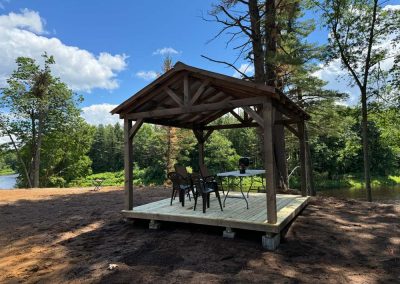 Amish pavilion with wood deck flooring set on a rural property