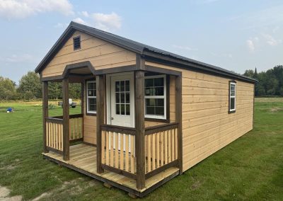 Amish cabin with covered porch overhang and black roof