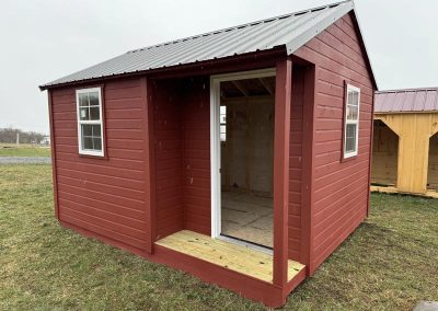 Small Amish built cabin with red siding and black metal roof