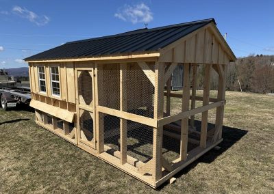 Long Amish chicken coop with screened sides and nesting boxes
