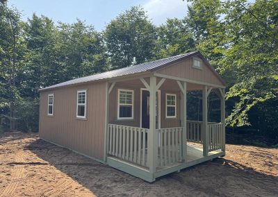 Amish cabin shed with covered porch and lattice railing