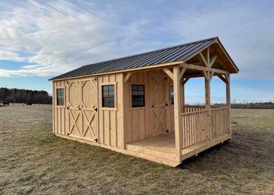 Amish shed with covered porch, black roof and barn-style doors