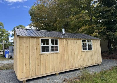 Amish shed with gray metal roof and side window