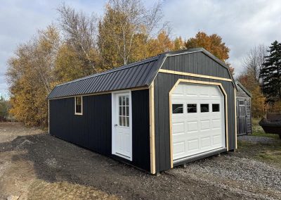 Black Amish shed with garage-style door and natural wood trim