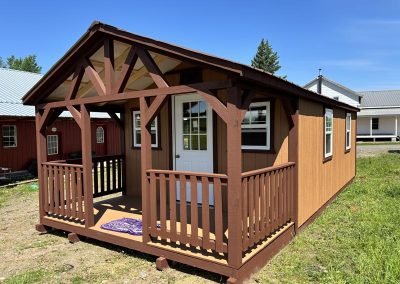 Amish cabin with covered porch, French doors and reddish siding