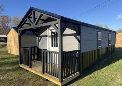 Amish cabin with covered porch and black and gray trim