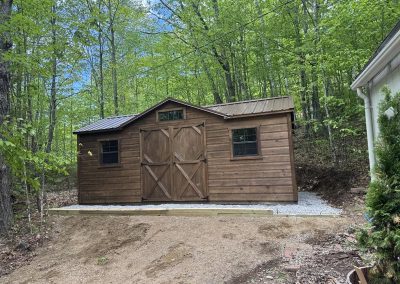 Amish shed with brown roof and double barn doors