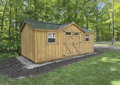 Amish shed with metal roof and double barn doors set in a yard
