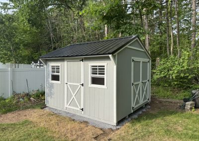 Gray shed with white trim and black roof