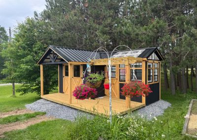 Brown and black shed with attached greenhouse