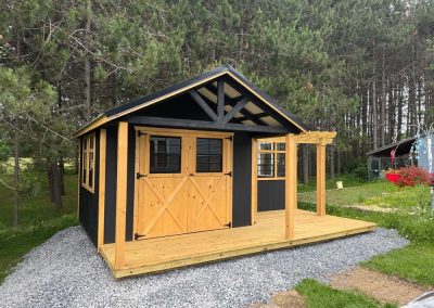 Beautiful Amish built brown and black shed with porch