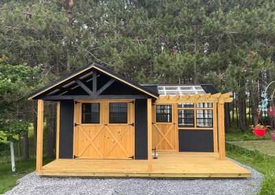 Amish shed with black roof, double doors and a gable window
