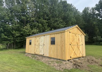 Wood Amish shed with black roof and single door