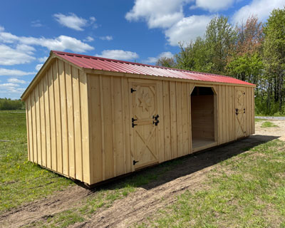 Amish made horse barn with two stalls and a red roof